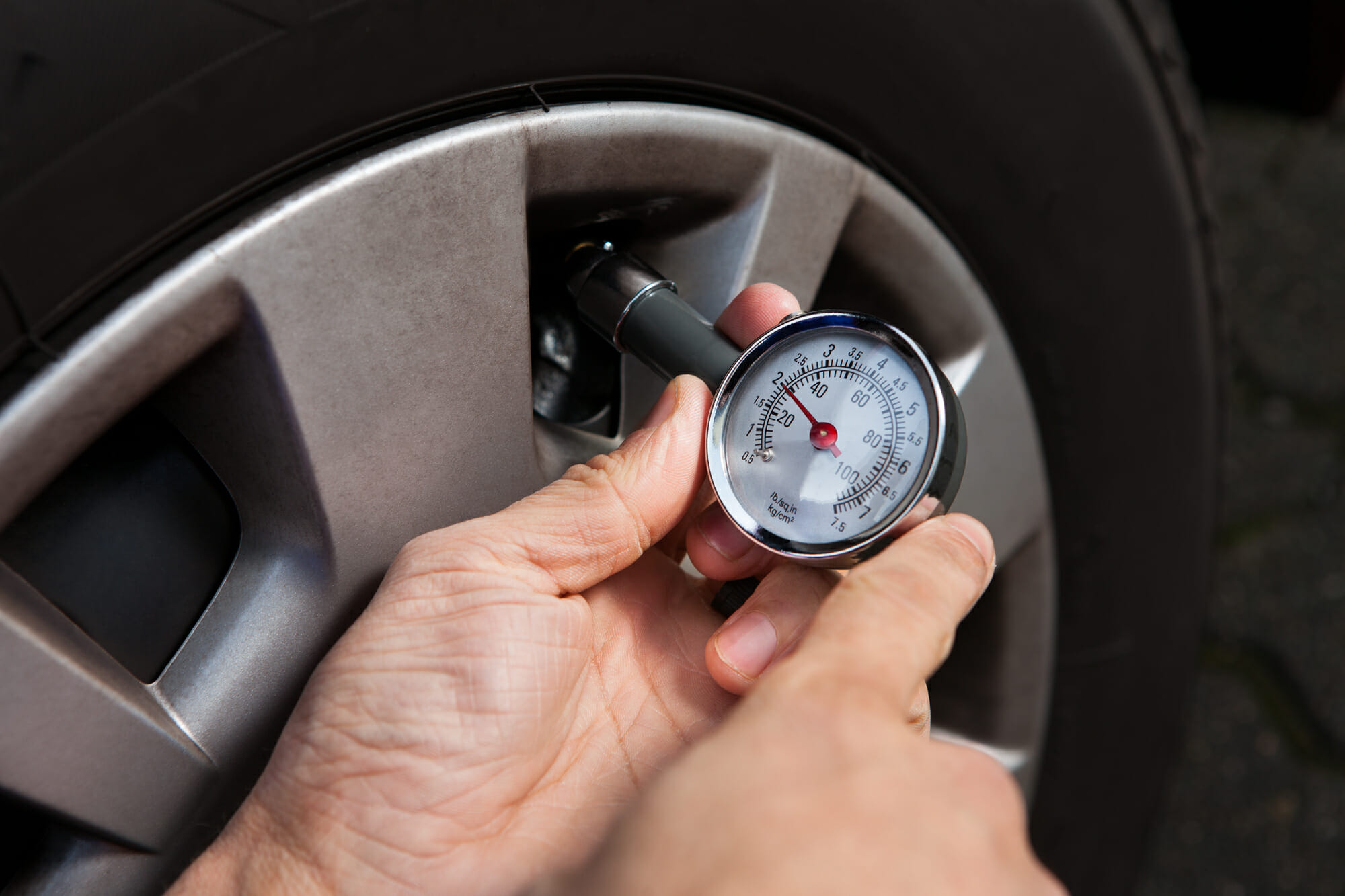 Mecánico de automóviles comprobando la presión de los neumáticos