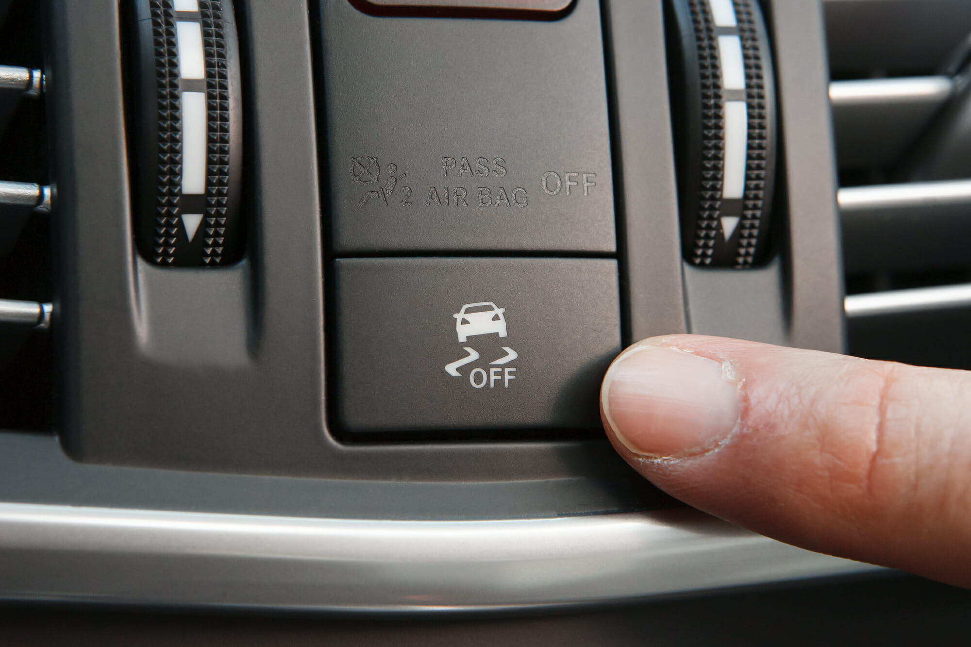 Conductor apuntando al botón de control de tracción del coche
