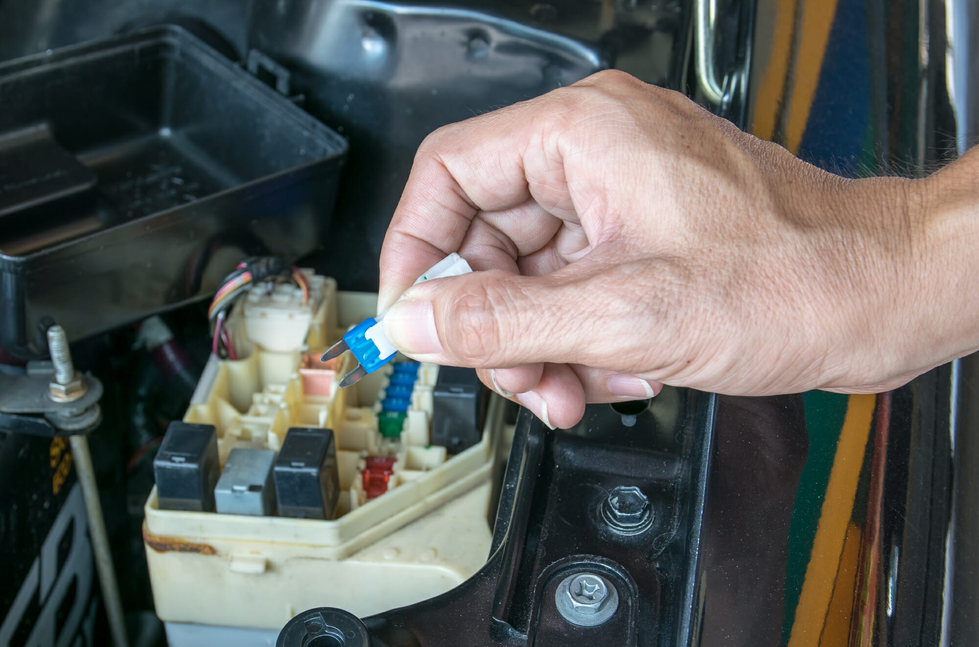 Mecánico de automóviles revisando la caja de fusibles de un automóvil