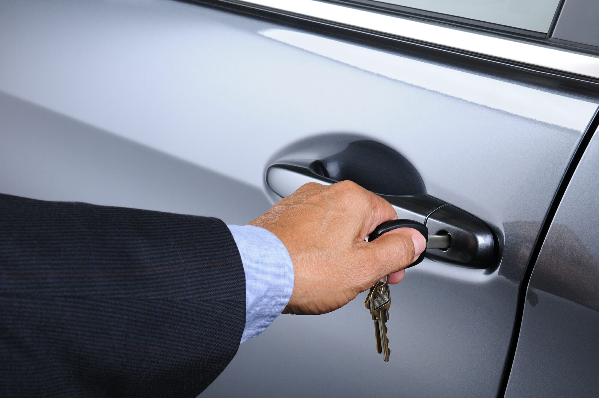 Conductor abriendo la puerta de un auto con una llave