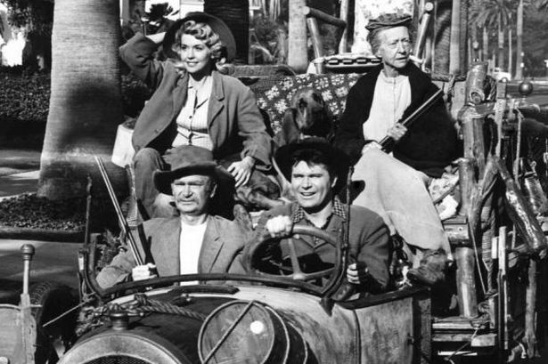 Los personajes de la serie de televisión The Beverly Hillbillies se desplazan en su Oldsmobile de 1921.