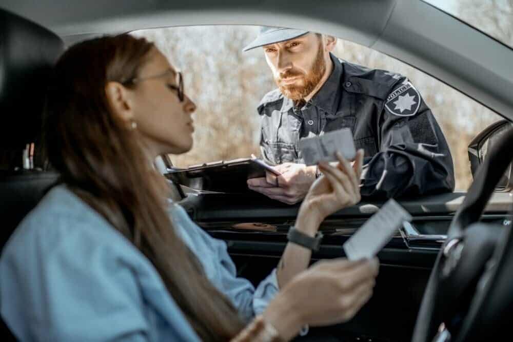 conductora mostrando su carnet a un policía