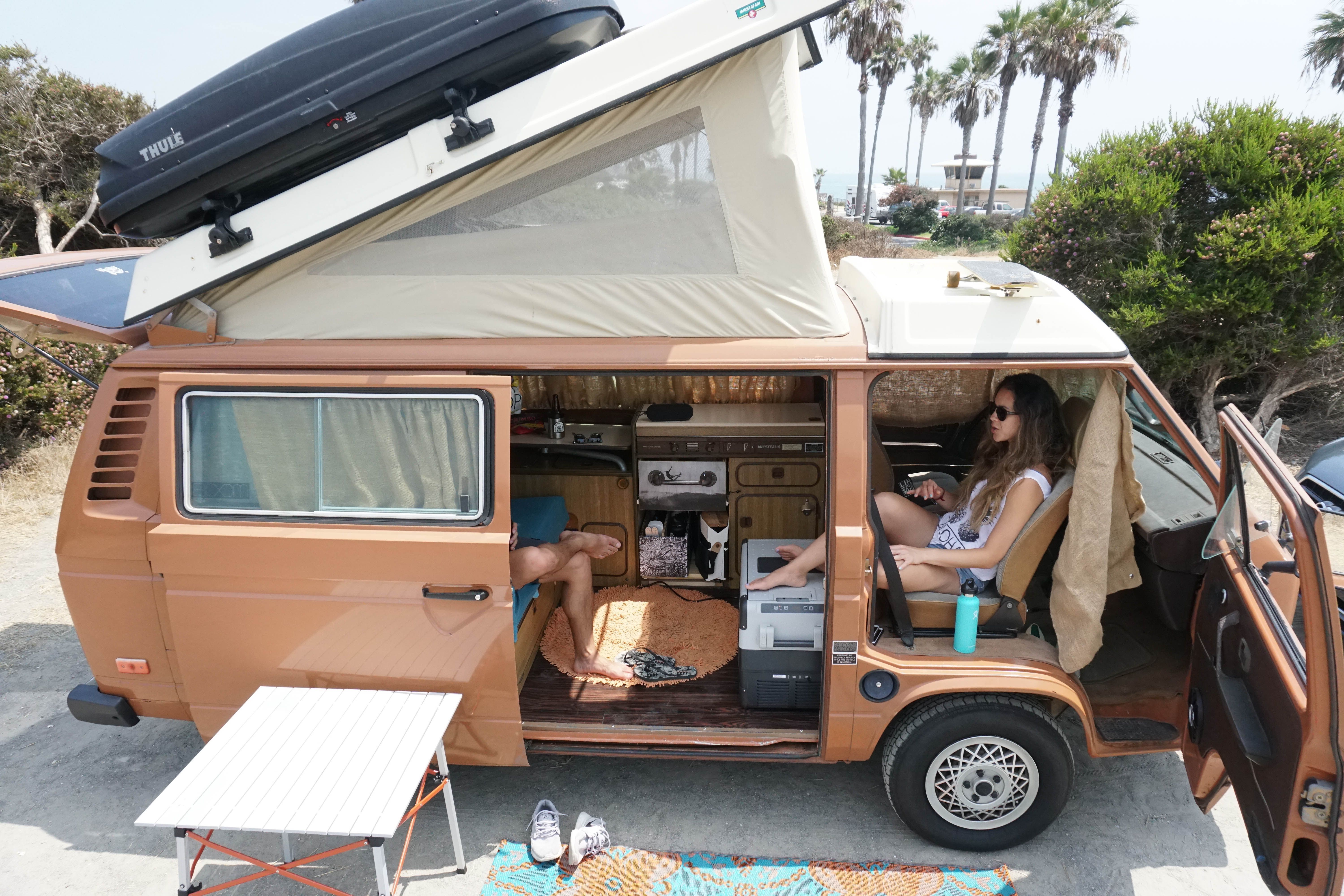 Relajándose en un camping en una VW Westfalia con la capota levantada