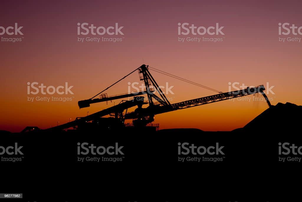 Apilador contra la puesta de sol en una mina de mineral de hierro Apilador en una mina de mineral de hierro Port Hedland Western Australia fotos de stock, fotos e imágenes libres de derechos